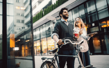 Smiling couple with a bike in the street