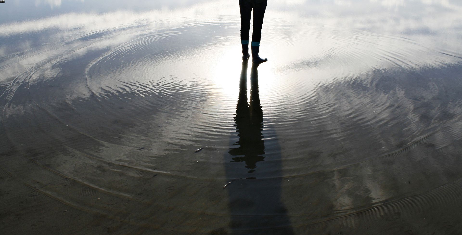 View of a person's feet standing in a shallow pool of water