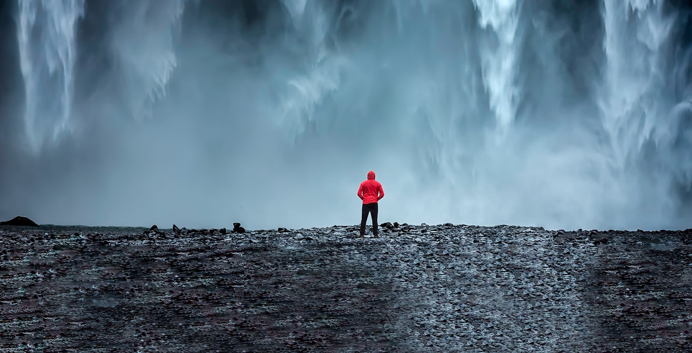 man standing in front of a waterfall